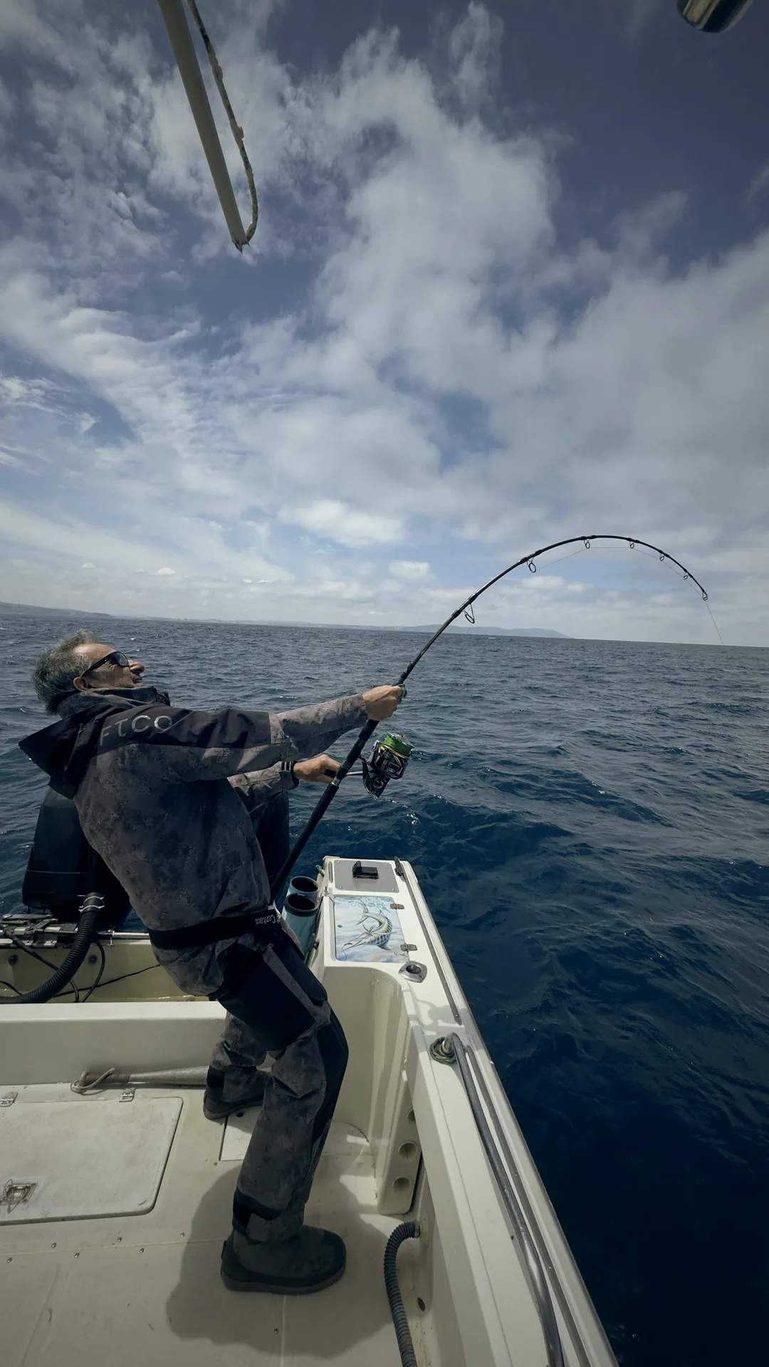 Captain Saad fighting a fish in heavy weather gear